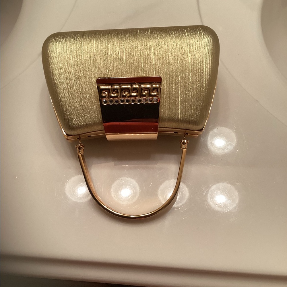 Small gold tone evening purse.  No tag but never used. Don’t know original cost